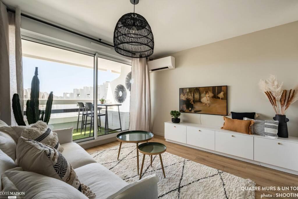 uma sala de estar com um sofá branco e uma mesa em Magnifique Studio - Beach Side Bliss em La Grande-Motte