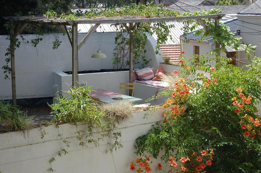 a garden with a pergola and some plants and flowers at Un jardin en ville in Nantes