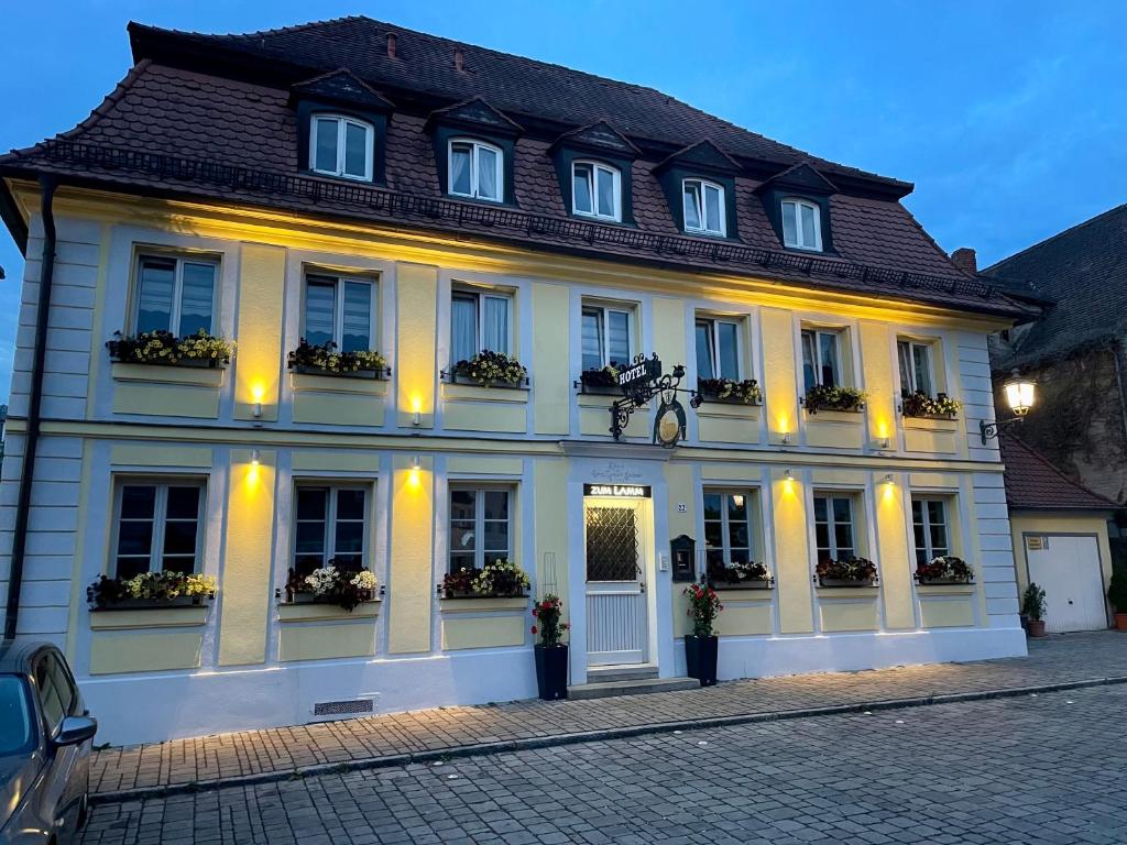 ein großes weißes Gebäude mit Fenstern und Pflanzen darauf in der Unterkunft Hotel Zum Lamm in Ansbach