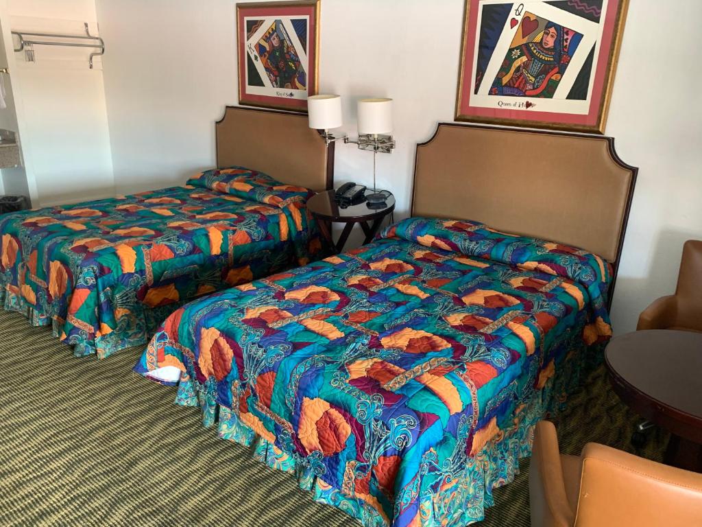a hotel room with two beds and a table at Deluxe Inn Austin in Austin