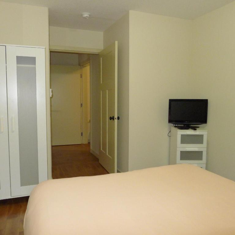 a bedroom with a bed and a flat screen tv at AnnArthur Guest House in Nanaimo