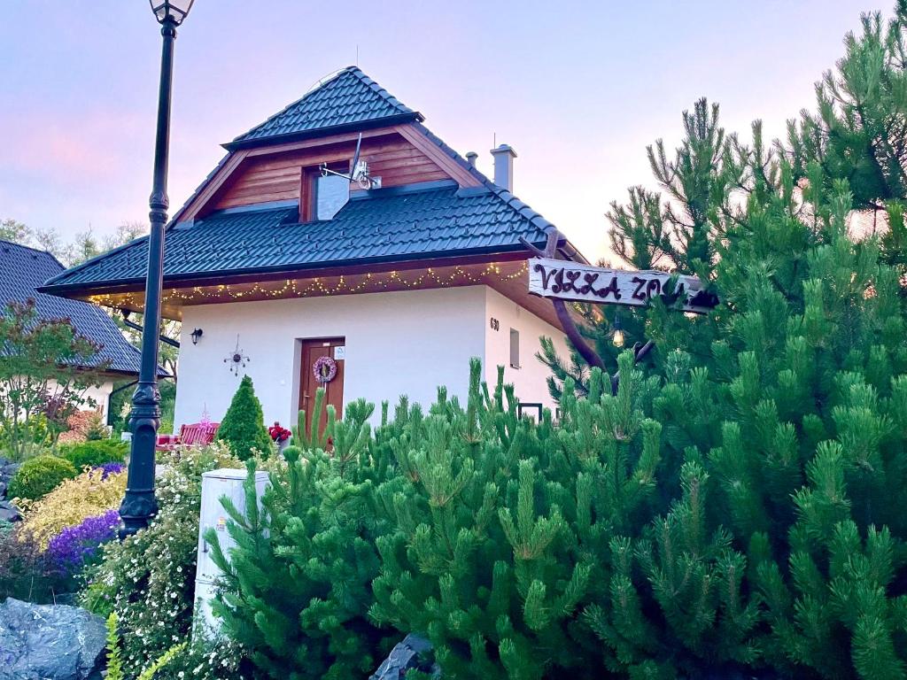 una casa con un cartel de calle en un jardín en Villa Zoja High Tatras, en Stará Lesná