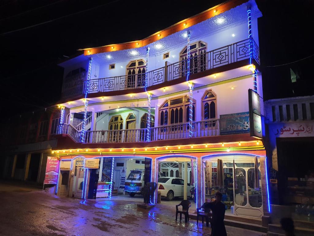 een wit gebouw met 's nachts verlichting bij Hotel Miandam Palace in Mingora