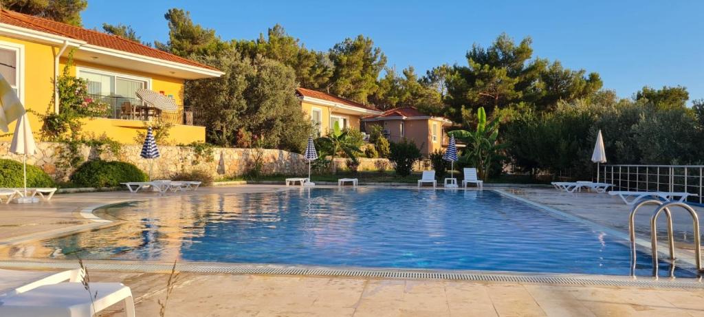 a swimming pool with chairs and a house at Charming Home Surrounded by Nature in Kas in Gelemiş