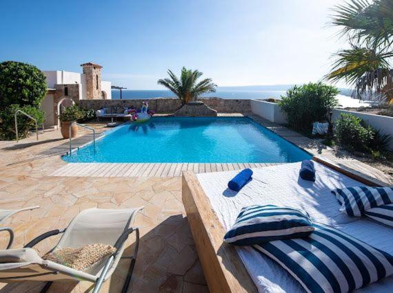 - une piscine avec une table et des chaises en face dans l'établissement El Penasco, à San Ferran de Ses Roques