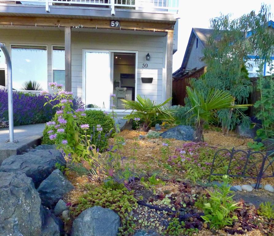a garden in front of a house with flowers at AnnArthur Guest House in Nanaimo