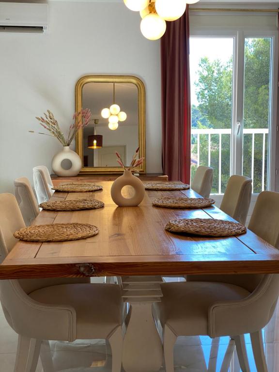 une grande table en bois avec des chaises et un miroir dans l'établissement Appart T3 tout équipé calme avec prairie et parking, à Toulon