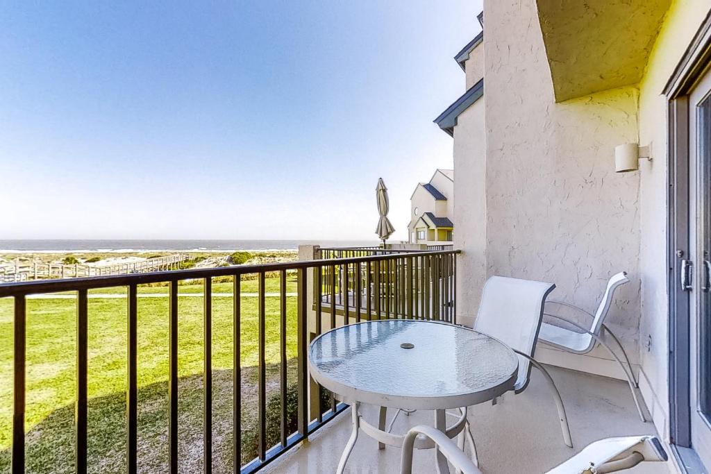 a table and chairs on a balcony with a view of the ocean at 207 Sailmaker in Fernandina Beach