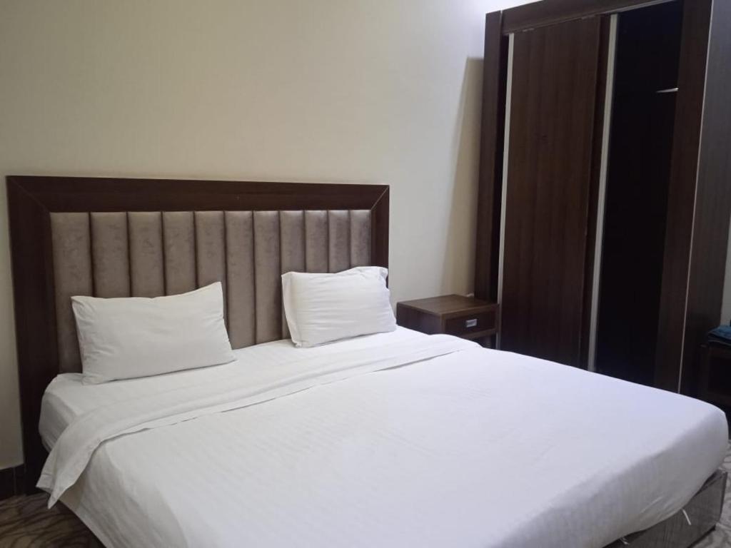 a bedroom with a large white bed with two pillows at Quiet Rooms 7 Serviced Apartments in Riyadh