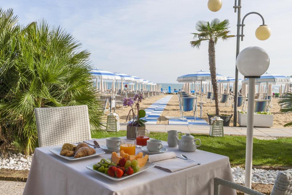 un tavolo con cibo sopra vicino alla spiaggia di Hotel Parioli a Lido di Jesolo