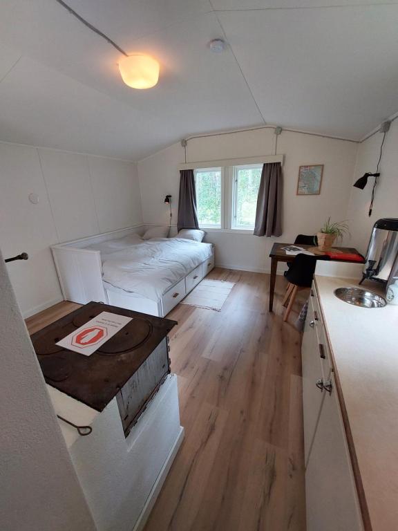 Schlafzimmer mit einem Bett, einem Schreibtisch und einem Tisch in der Unterkunft Linsell stuga in Linsell