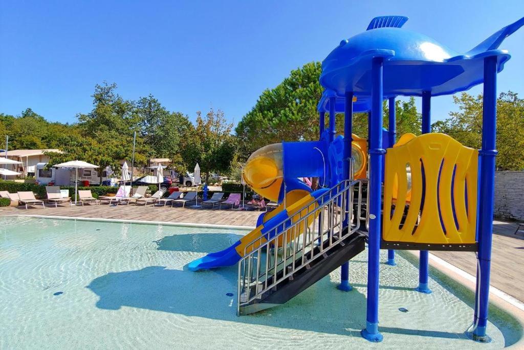 a blue and yellow playground in a swimming pool at Polidor Glamping Resort in Poreč