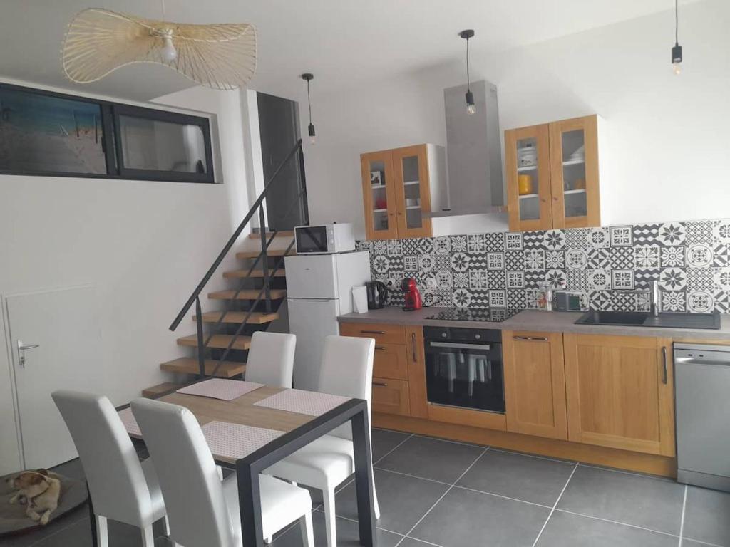 a kitchen with a table and chairs and a staircase at Le gîte lorette in Épinal