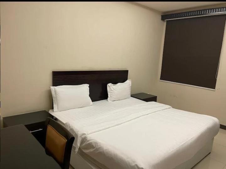 sypialnia z dużym łóżkiem z białą pościelą w obiekcie Quiet Rooms 8 w Rijadzie