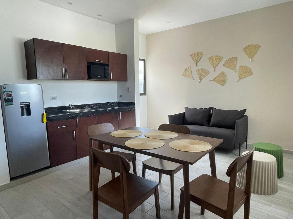 a living room with a table and a kitchen at Excelente Departamento en planta baja colonia Altabrisa in Mérida