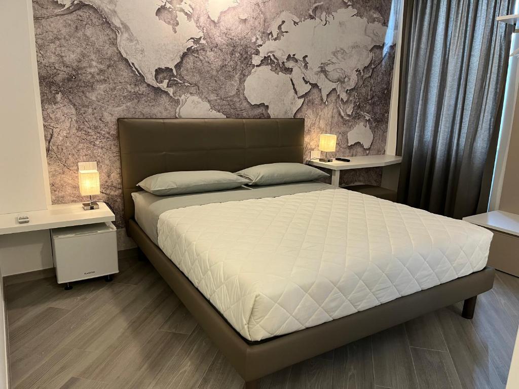 um quarto com uma cama com duas mesas e um mapa na parede em B&B LA ROSA DEI VENTI em Civitanova Marche