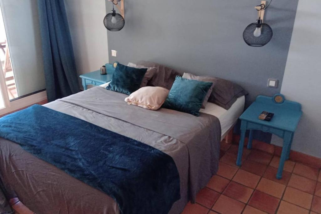 a bedroom with a bed and a blue table at Studio Zen Island Tartane in La Trinité