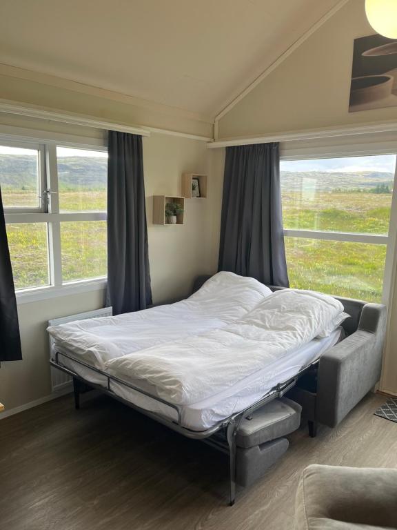 a bed in a room with a large window at Sun-cottage South Iceland in Ölfus