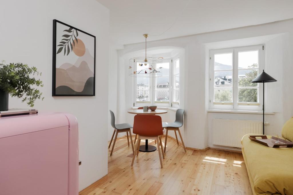a white living room with a table and chairs at Das Grüne Haus - Boutique Apartments ecofriendly in Innsbruck