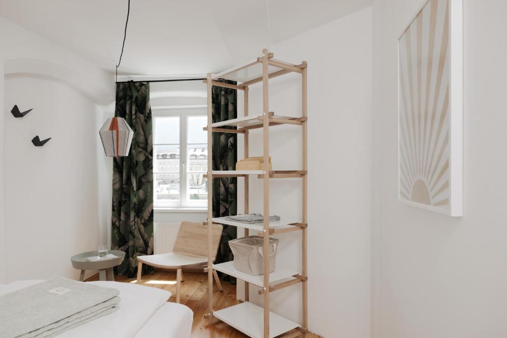 a room with a book shelf next to a bed at Das Grüne Haus - Boutique Apartments ecofriendly in Innsbruck