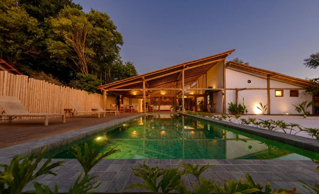 a swimming pool in the backyard of a house at Pousada Nossa Casa Cumuruxatiba in Cumuruxatiba