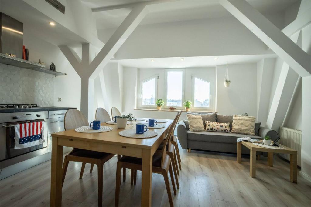 een keuken en een woonkamer met een tafel en een bank bij Centric Rooftop 4 bedroom apartment in Łódź