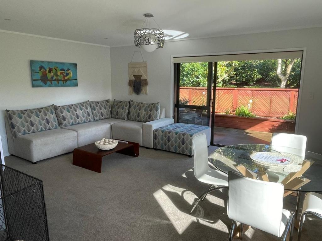 a living room with a couch and a table at Baybell Lodge in Omanawa