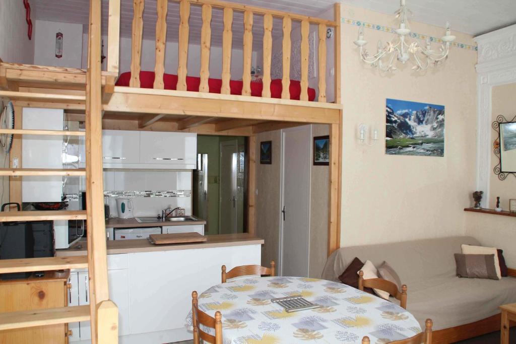 a room with a dining table and a loft bed at Bel appt 3 * plein Centre ville 4 pers. + balcon in Cauterets