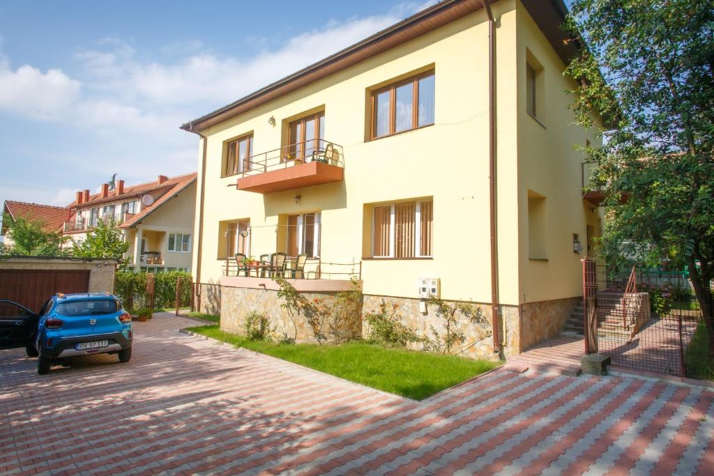 a house with a car parked in front of it at Barok Apartments in Braşov