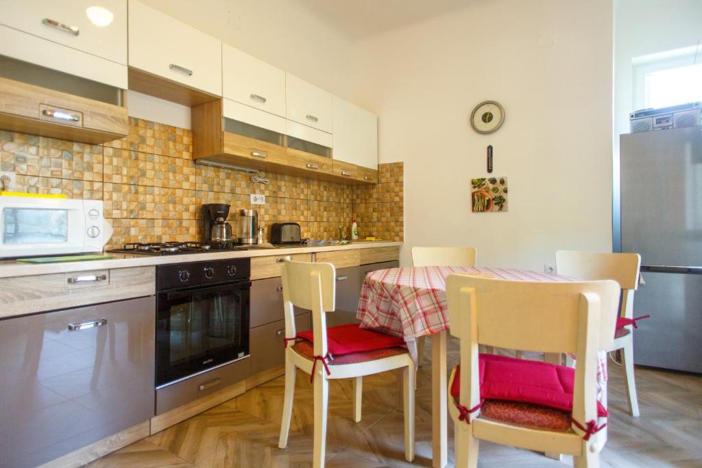 a kitchen with a table and chairs and a microwave at Barok Apartments in Braşov