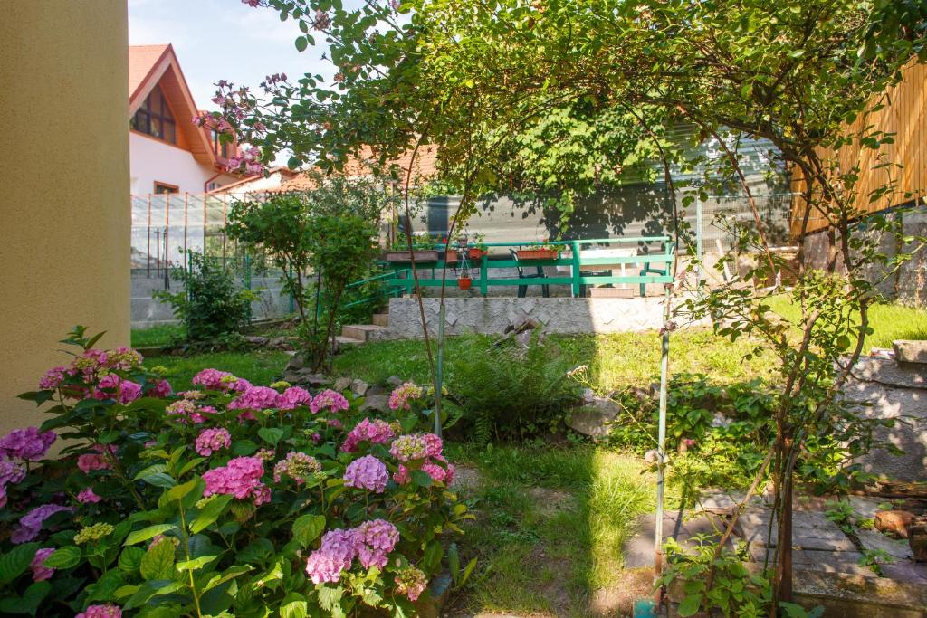 a garden with flowers and a bench in the background at Barok Apartments in Braşov