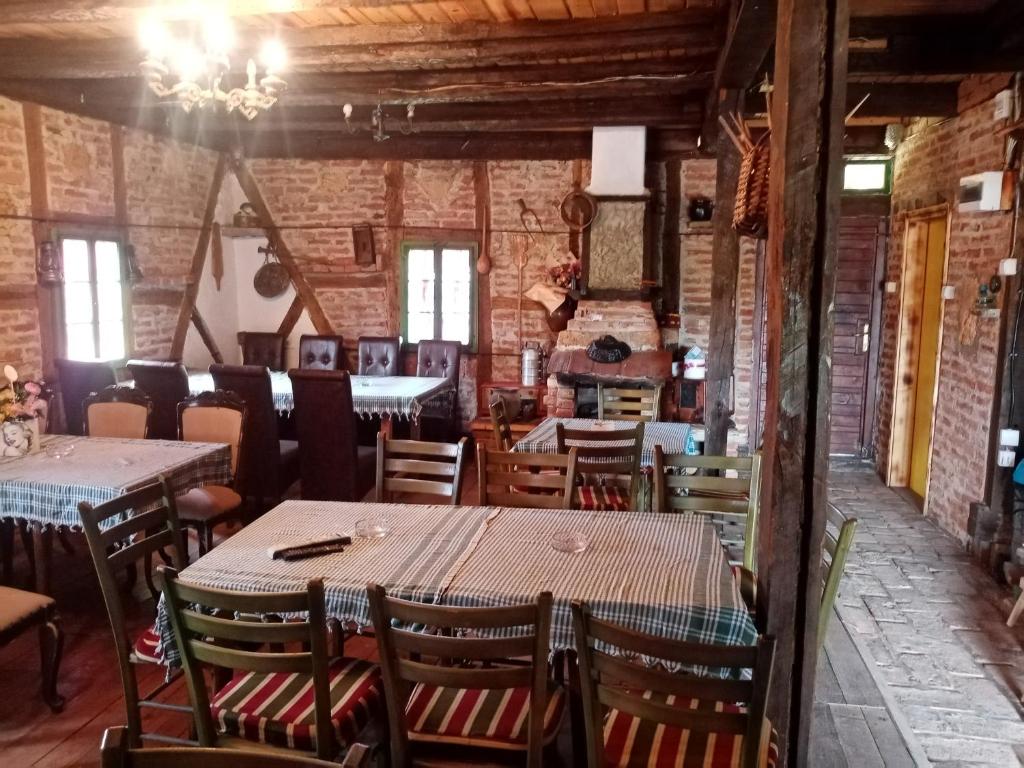 um restaurante com mesas e cadeiras e uma parede de tijolos em KONACI ČAKAREVIC 