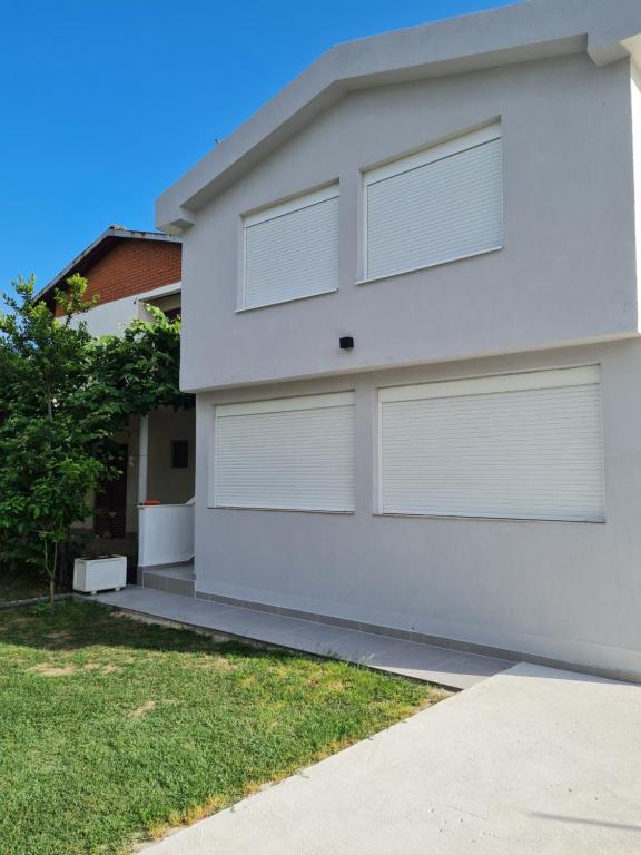 a white house with two garage doors at Demir Apartmani in Donji Štoj