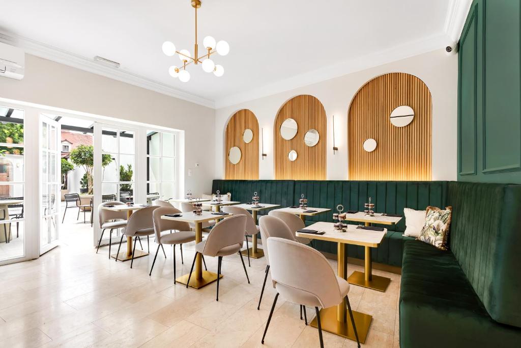 een restaurant met tafels en stoelen en een groene muur bij Bloom Hotel in Ljubljana