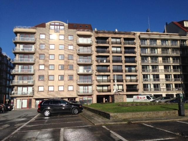 a car parked in a parking lot in front of a building at Apartment Bel-Air in Knokke-Heist