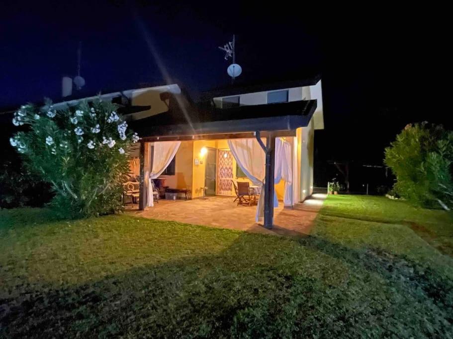 a backyard at night with a gazebo at Villa con porticato sul prato in Isola Albarella