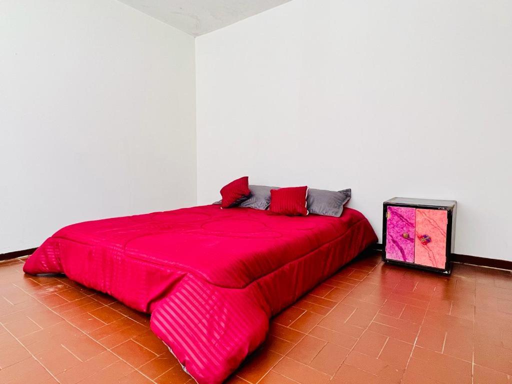 um quarto com uma cama grande e um cobertor vermelho em Museo del Oro em Bogotá