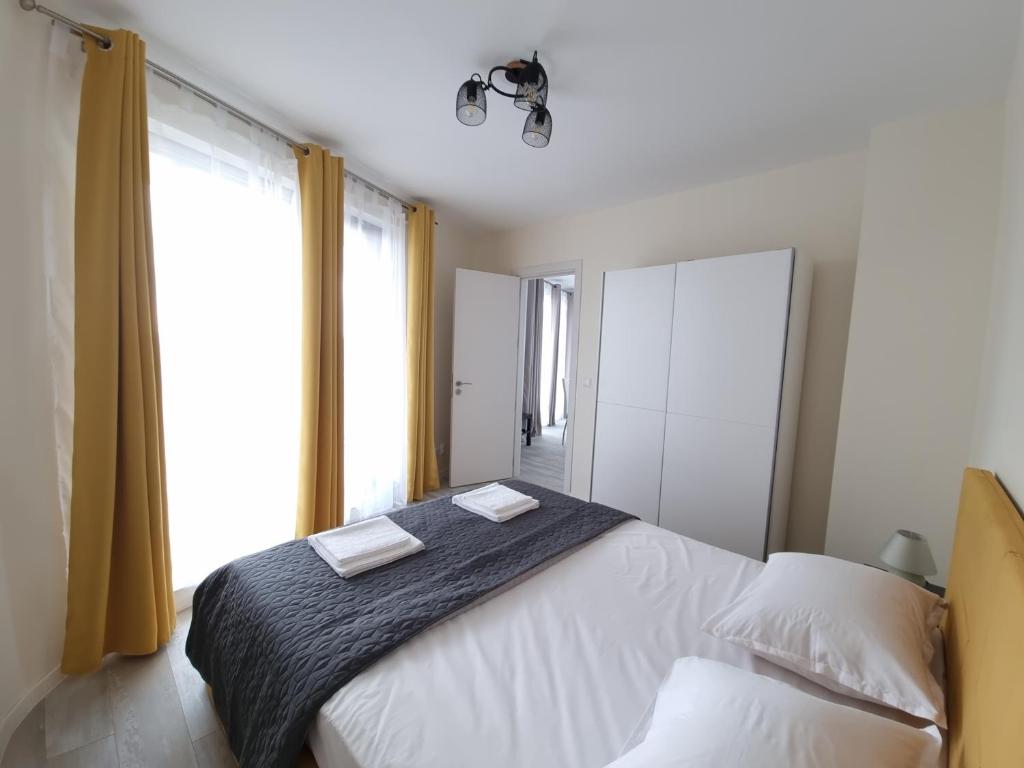 a bedroom with a large white bed and a window at Апартамент Орех А30 in Varna City