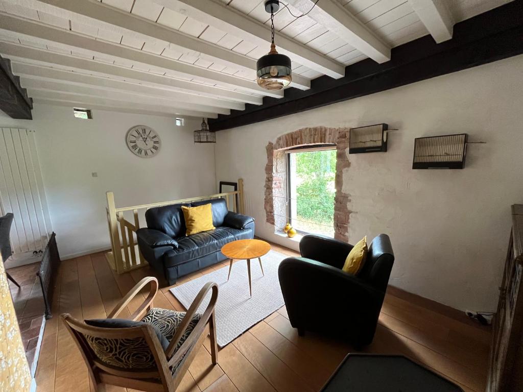 uma sala de estar com um sofá azul e cadeiras em Le nid Mésange em Alligny-en-Morvan