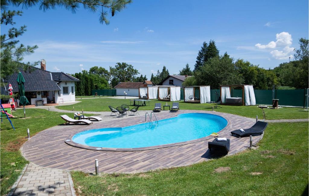 a swimming pool in a yard with chairs at 4 Bedroom Lovely Home In Fericanci in FeriÄanci