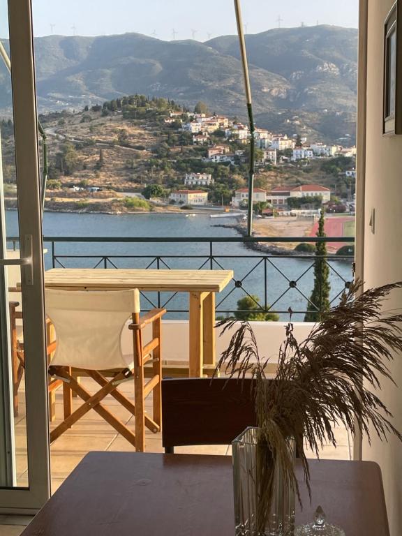 einen Balkon mit einem Tisch und Blick auf das Wasser in der Unterkunft The view in Poros