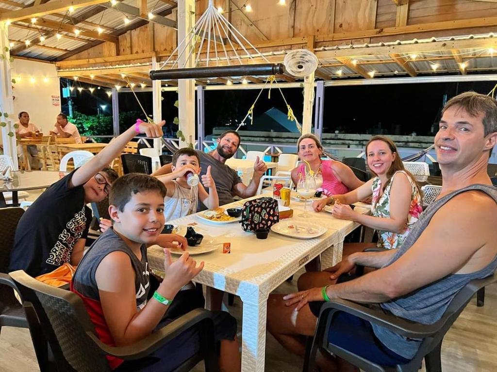 um grupo de pessoas sentadas à volta de uma mesa em Posada Lia Centro em Providencia