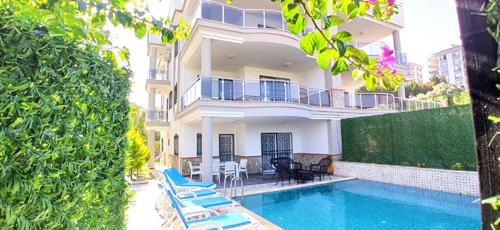 une villa avec une piscine et un bâtiment dans l'établissement Begonville Villas Ladies Beach, à Kusadası
