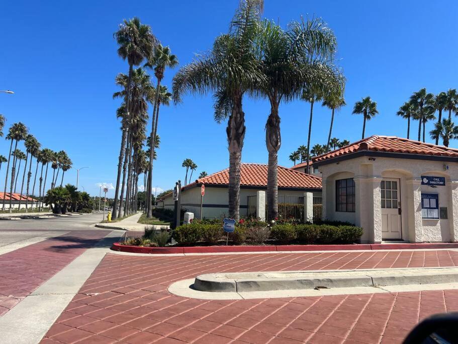 a building with palm trees in front of a street at Paradise resort living Mandalay beach in Oxnard