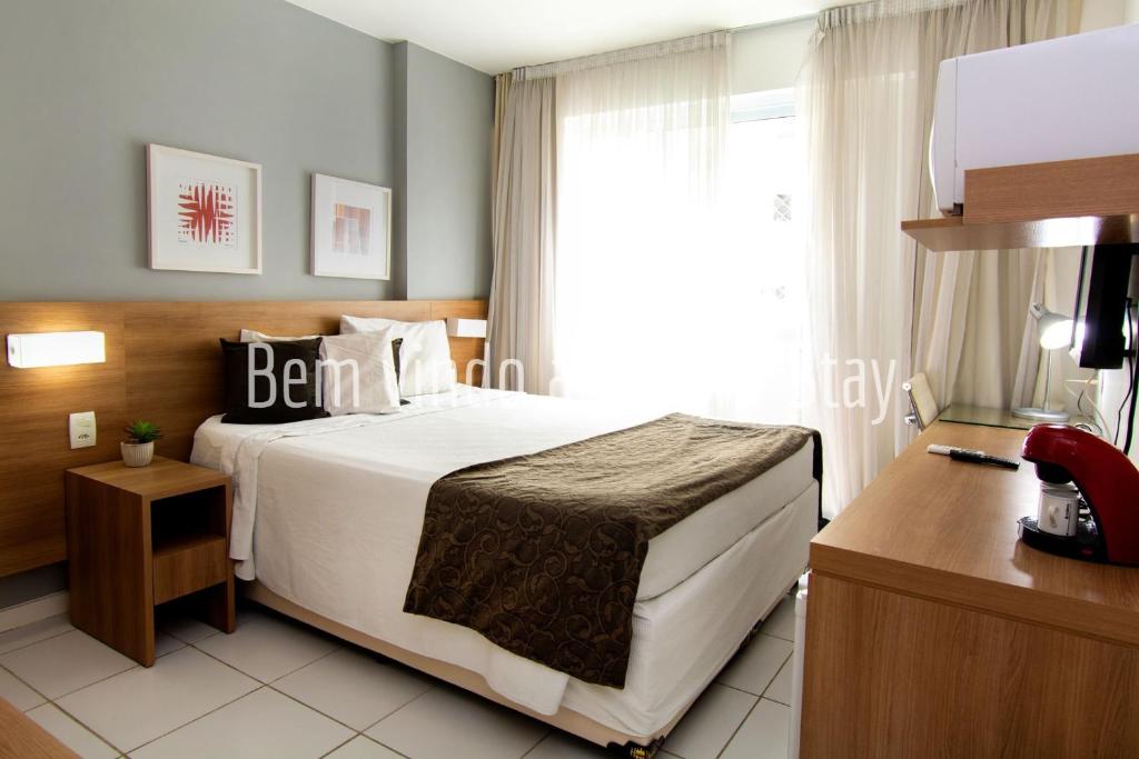 Habitación de hotel con cama y ventana en 10 Suite Verano Stay Barra, en Río de Janeiro