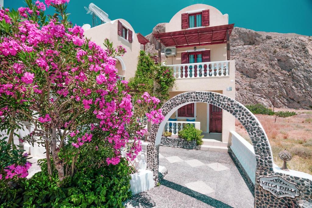 una casa con fiori rosa di fronte di Villa Dima a Perissa