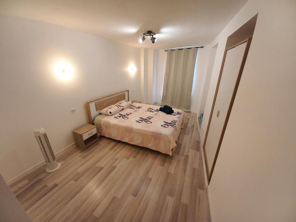 a small bedroom with a bed and a wooden floor at Maison à 5 minutes du lac à pied in Aix-les-Bains