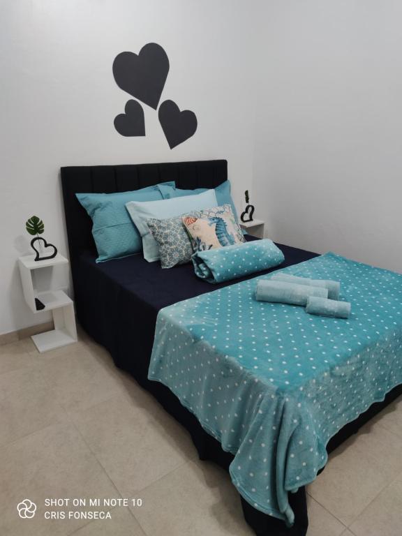 1 dormitorio con 1 cama con sábanas azules y corazones en la pared en Hospedagem MAR SANTO en Florianópolis