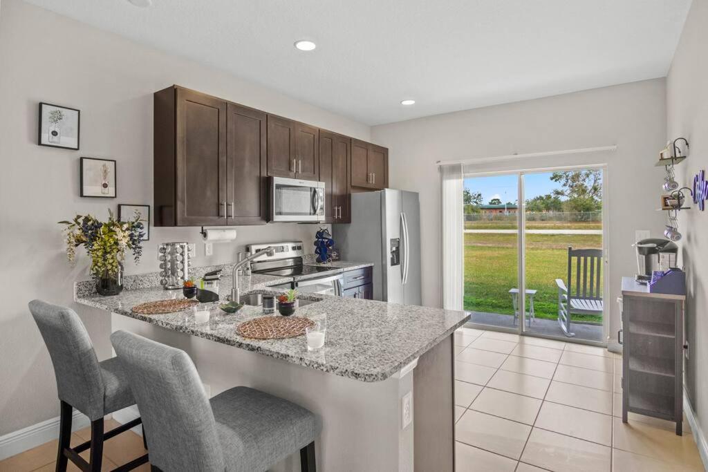 a kitchen with a counter with chairs and a counter top at Luxury and tranquility, In the Heart of Poinciana, just 30 min from Disney! in Poinciana