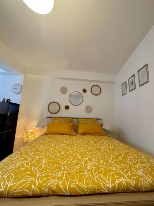 a bedroom with a bed with a yellow bedspread at Appartement neuf entièrement équipé proche centre in Amiens